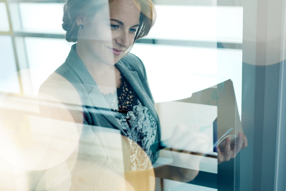 Filtered portrait of an executive business woman writing on a glass wall at sunset-1