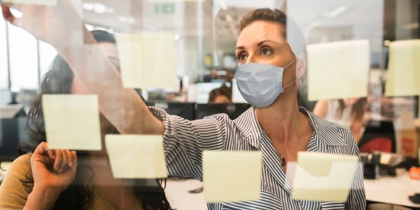 businesswomen-working-together-behind-glass-wall-with-reflections-picture-id1215986933 (1)
